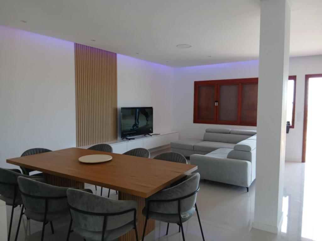a dining room and living room with a table and chairs at Cabouqueiro's House in Mateuzinho
