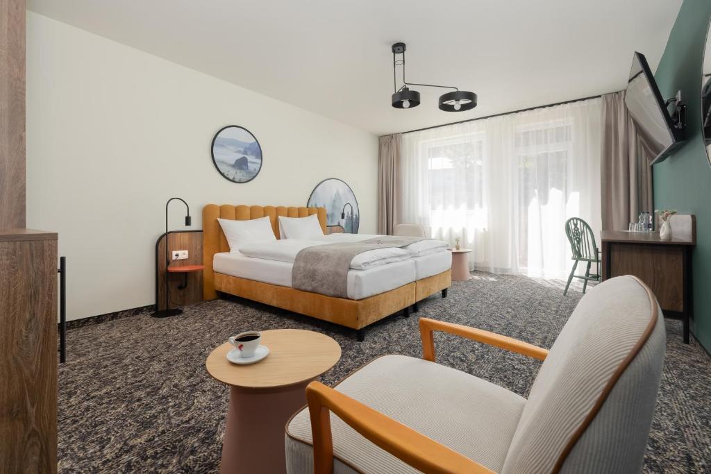 a bedroom with a bed and a living room at Santa Christina Mountain Resort in Świeradów-Zdrój