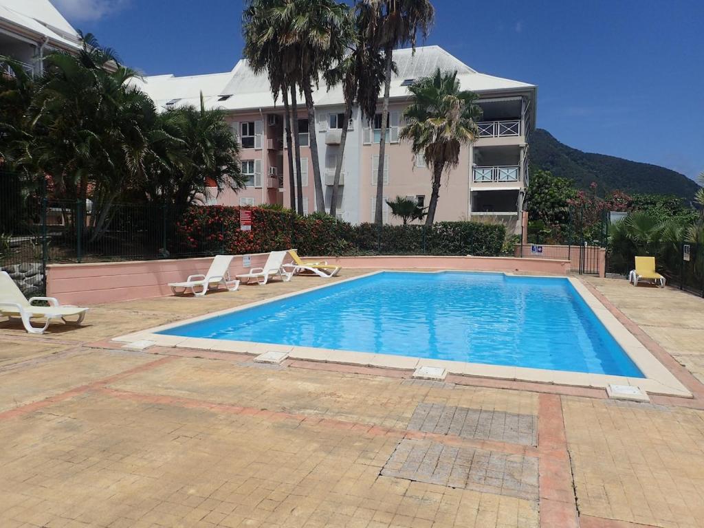a swimming pool in front of a building at Résidence les Antillannes in Gourbeyre