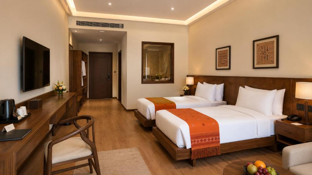 a hotel room with two beds and a desk at Terma Linca Paro in Paro