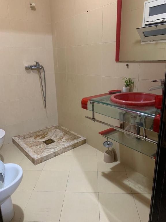 a bathroom with a red sink and a toilet at Rayan in Tangier