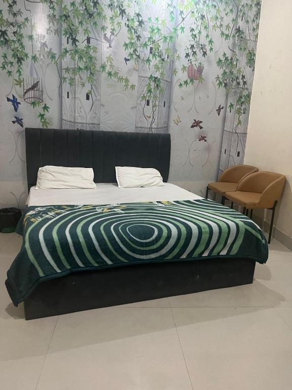 a bed with a green and white blanket on it at Skyline hotel in Barnāla