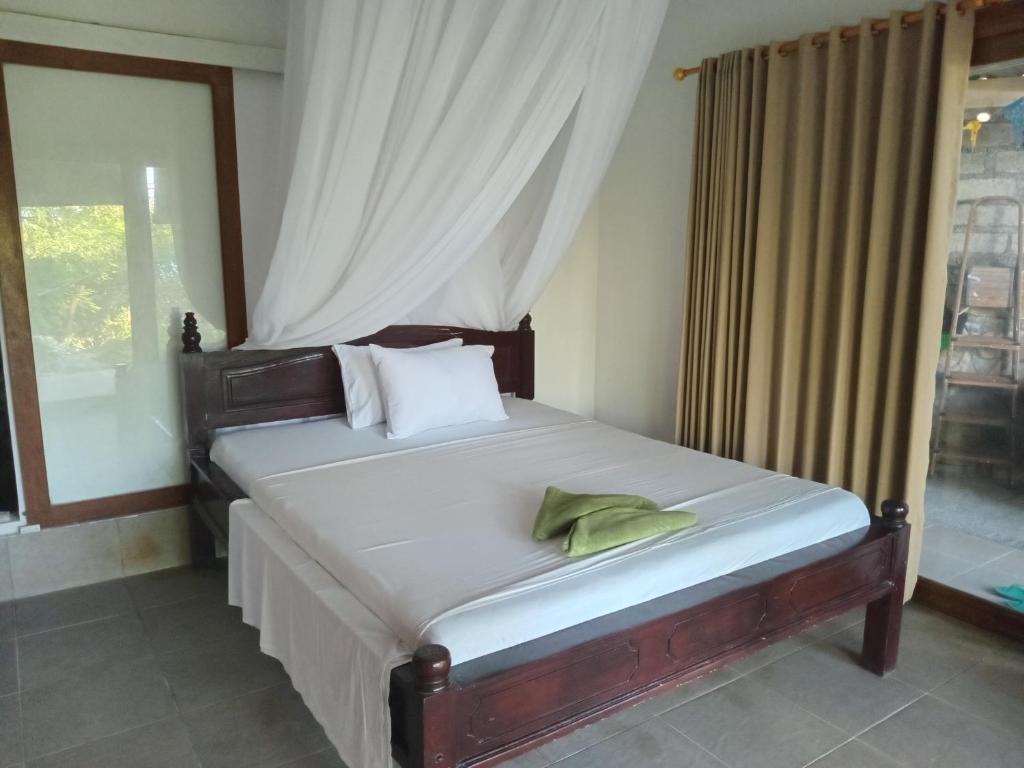 a bedroom with a large bed with a window at Nyoman Guest House 1 in Ambat