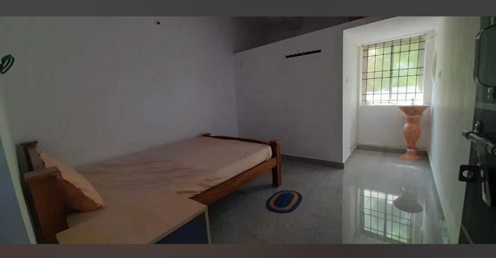 a small bedroom with a bed and a window at River valley Homestay in Hanbalu
