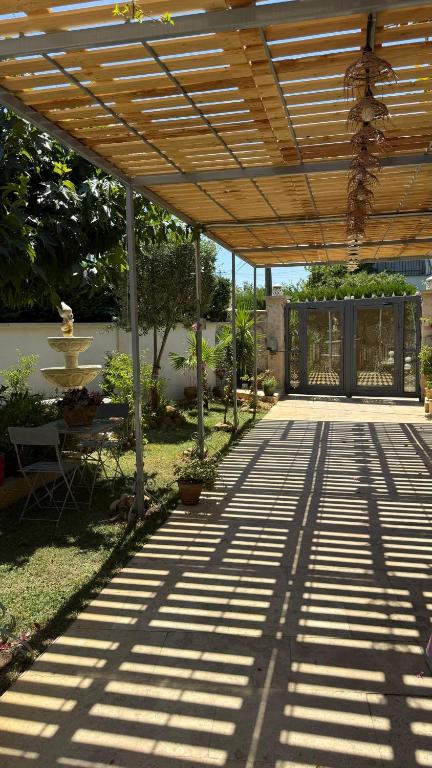 a patio with a wooden pergola in a garden at Superbe T2 au rez-de-chaussée avec jardin in Arles
