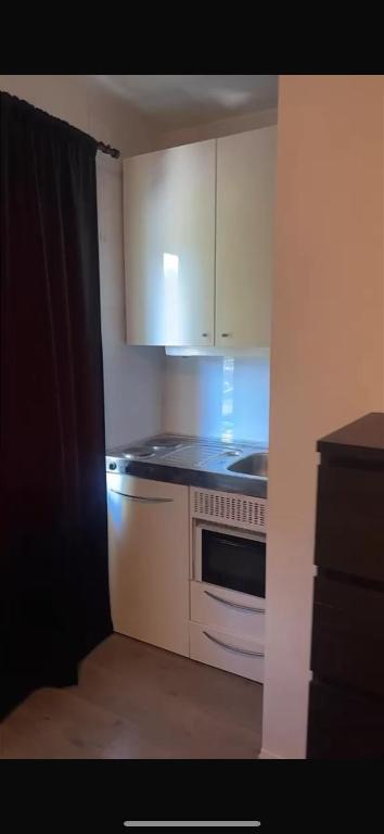 a kitchen with white cabinets and a stove at Studio in Fjellhammar