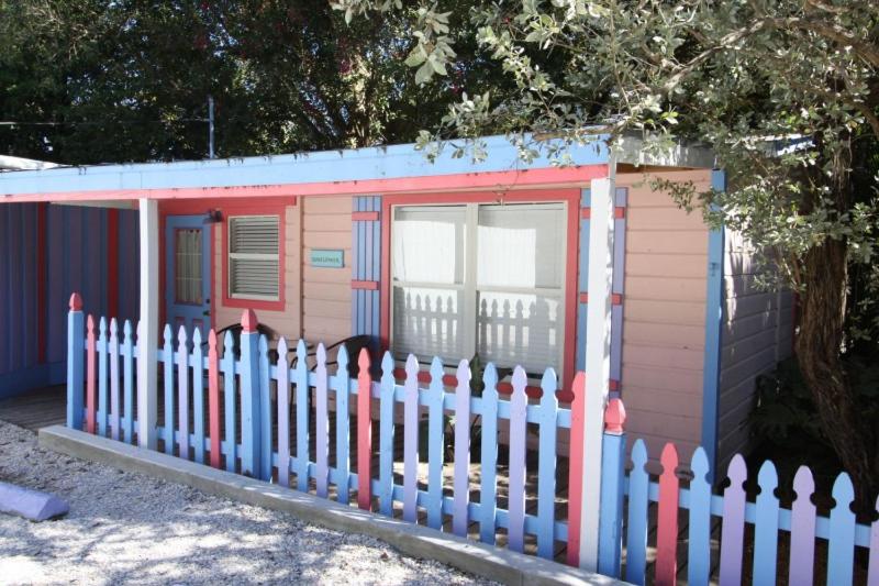 a small pink and blue house with a fence at Captiva Island Inn in Captiva