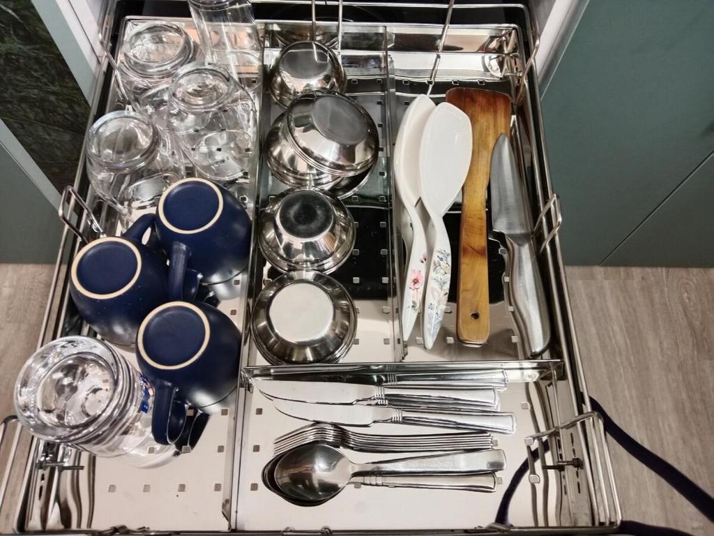 a dish drying rack with dishes and utensils at Stupas, Temples and Coffee 2BR Flat in Kathmandu in Kathmandu