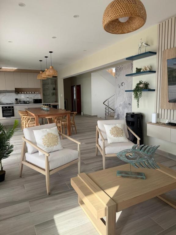 a living room with two chairs and a table at Casa Marena Punta Sal in La Bocana