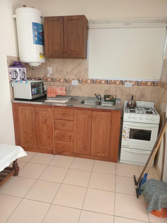 a kitchen with a white stove and a sink at Coastal Apartment in Monte Caseros