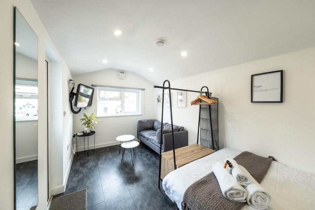 a bedroom with a bed and a couch in it at The Snug - Cosy Annexe Hideaway in Portishead