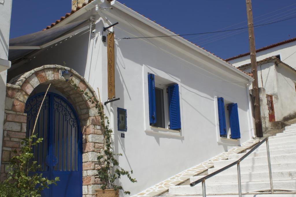 an entrance to a white house with blue shutters at Skalopetra in Pylos