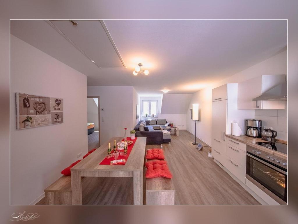 a kitchen and living room with a table and a couch at Fewo Müritzfrische 2 in Waren