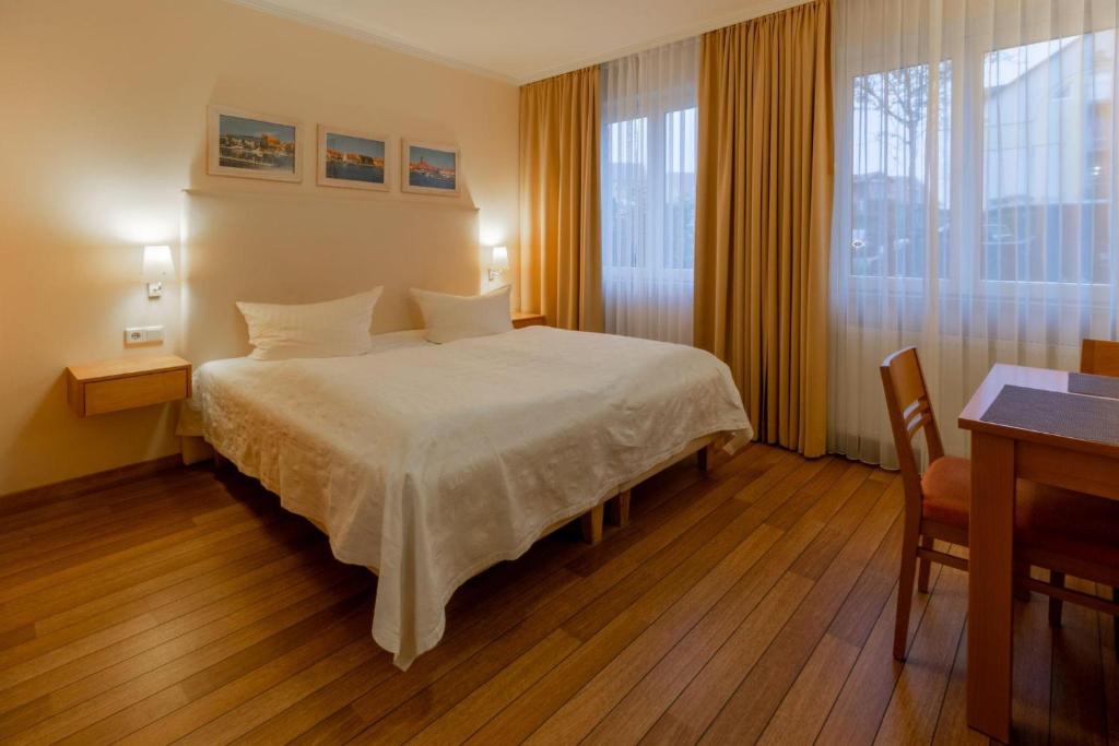 a bedroom with a bed and a desk and a window at Hafendomicil Appartement WH04 - Igel in Waren