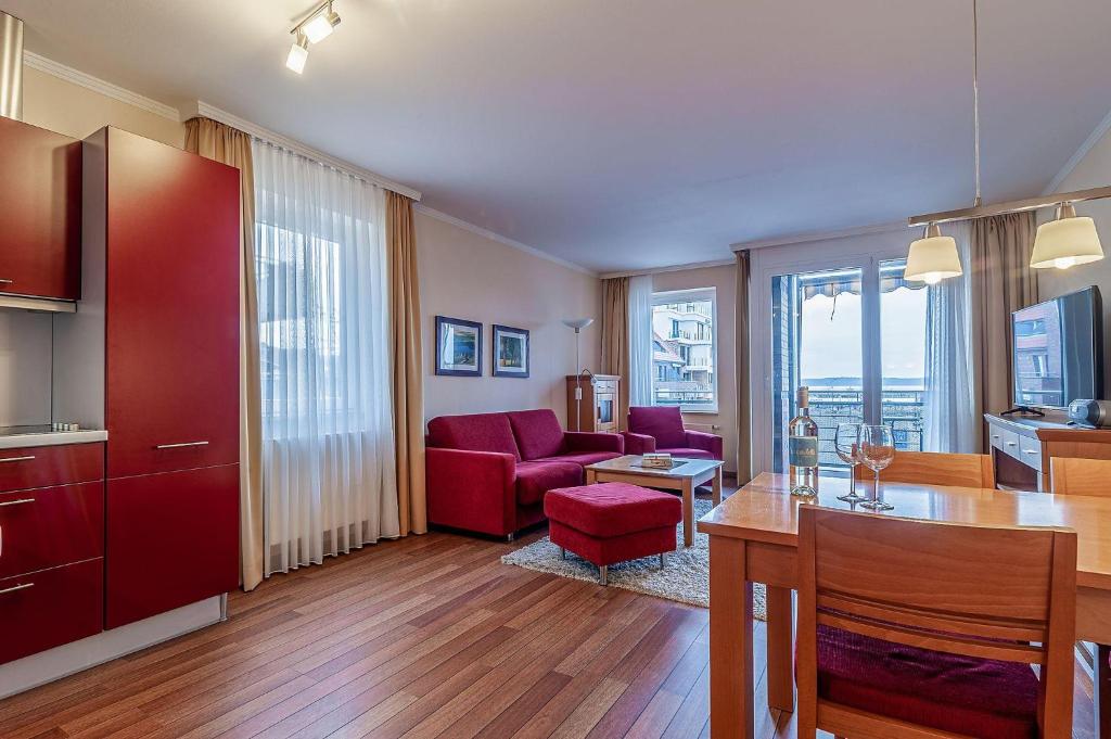 a living room with a red couch and a table at Hafendomicil Appartement WH06 - Hase in Waren