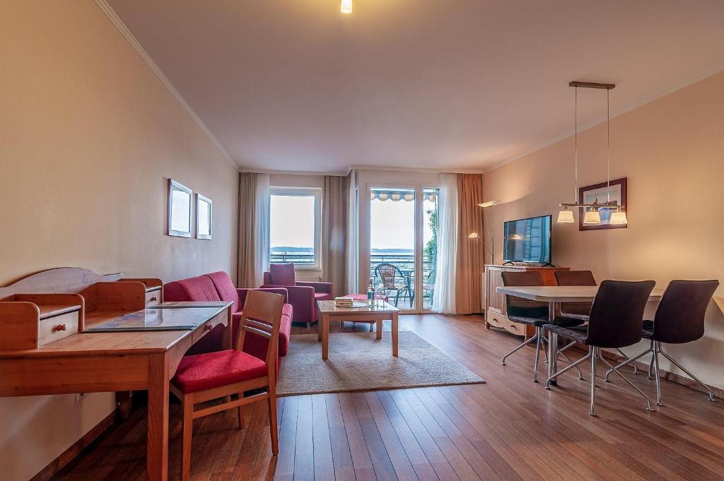 a living room with a table and chairs and a dining room at Hafendomicil Appartement WH07 - Fuchs in Waren