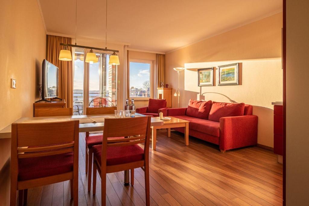 a living room with a red couch and a table at Hafendomicil Appartement WH13 - Eisvogel in Waren