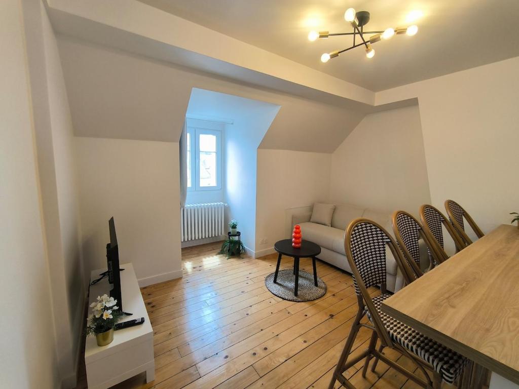 a living room with a table and chairs and a couch at Hyper Centre Beauvais Cosy Appartement in Beauvais