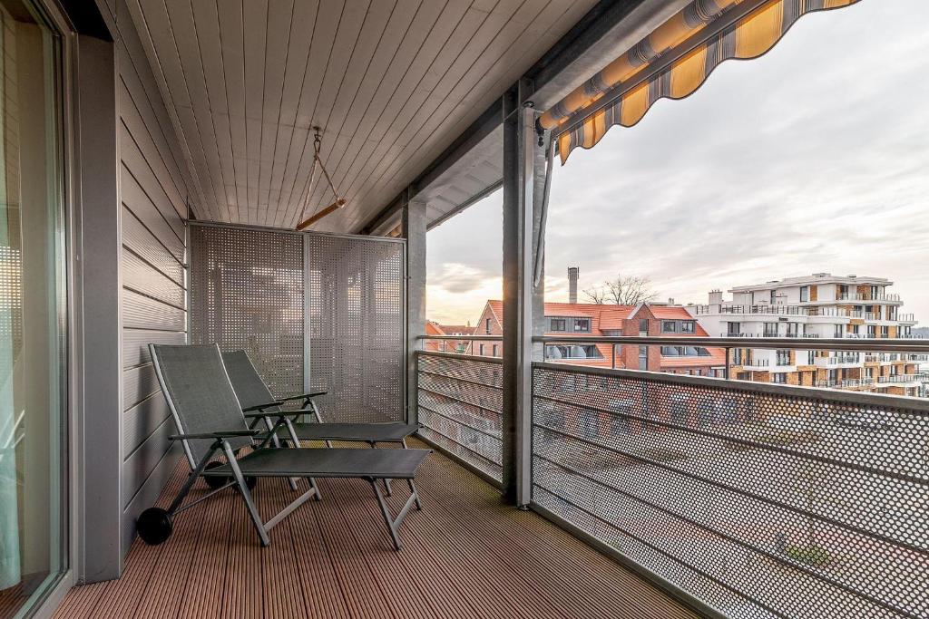 a balcony with two chairs and a view of a city at Hafendomicil Appartement WH15 - Adler in Waren