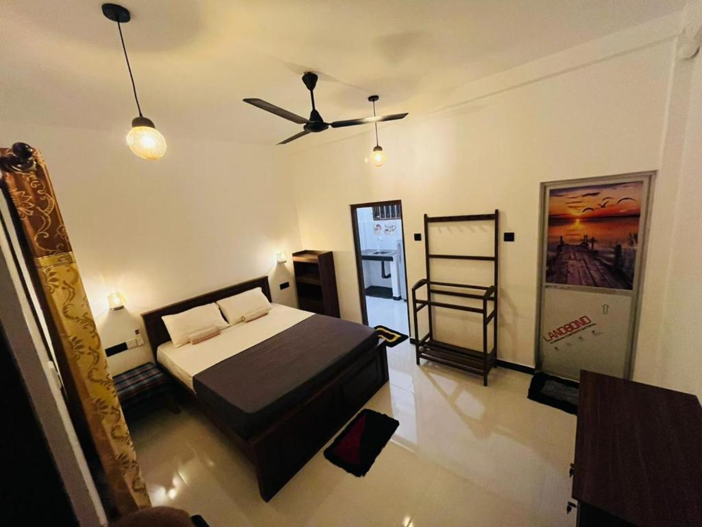 a bedroom with a bed and a ceiling fan at Sasaa Guest House in Mirissa