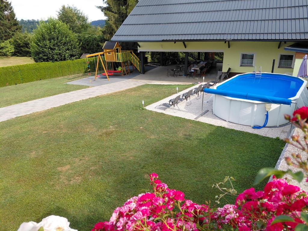 a backyard with a pool and a playground at Apartment and Studios Jelovca & Wellness in Radovljica
