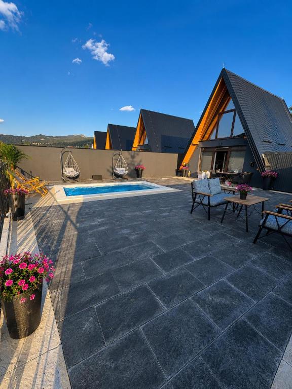 a stone patio with a house and a pool at Weekend house - Vlašić in Vlasic