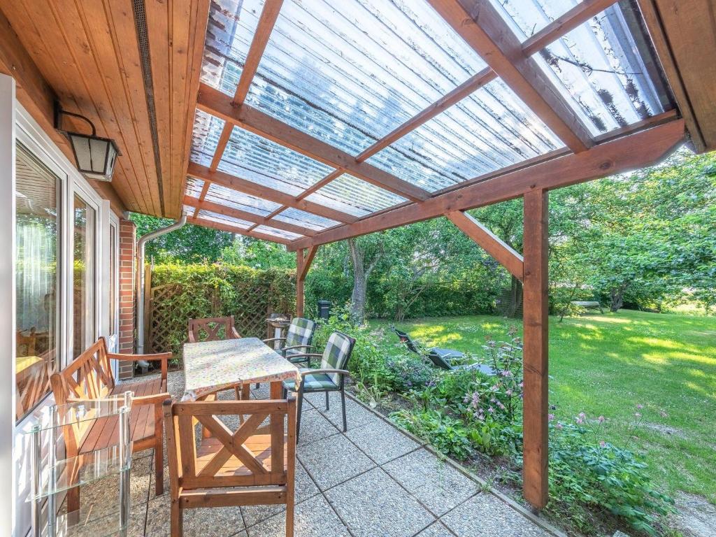 a pergola on a patio with a table and chairs at Luett Huus in Lärz