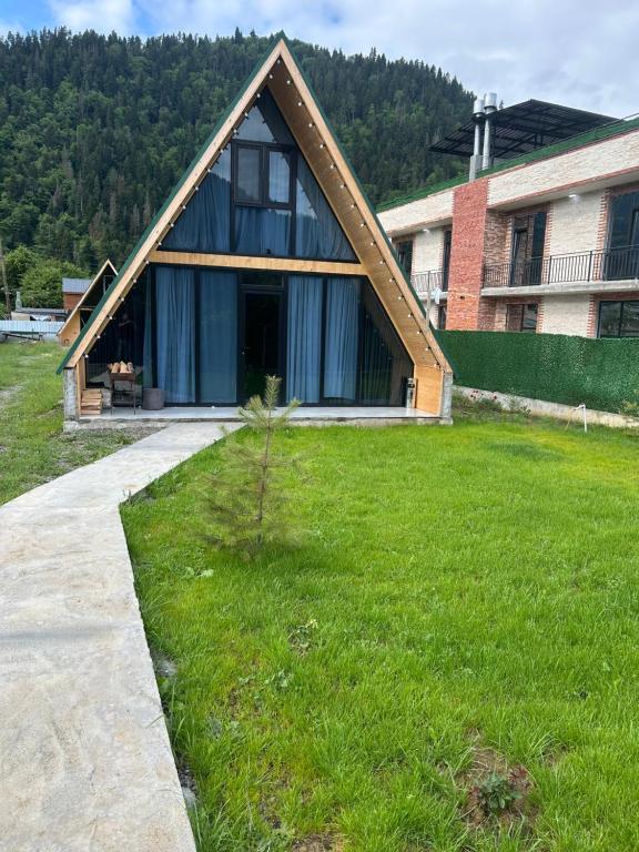 a house with a gambrel roof on a yard at Cottage Godzia in Sadgeri