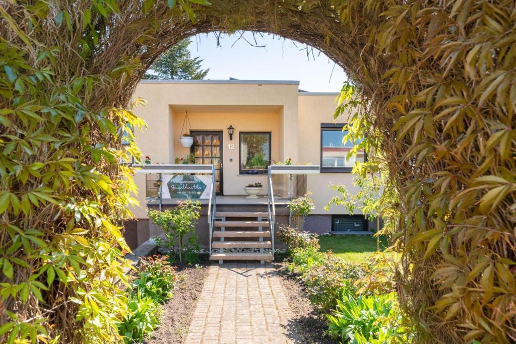a house viewed through an archway in a garden at Die Jagdhütte in Dedelow