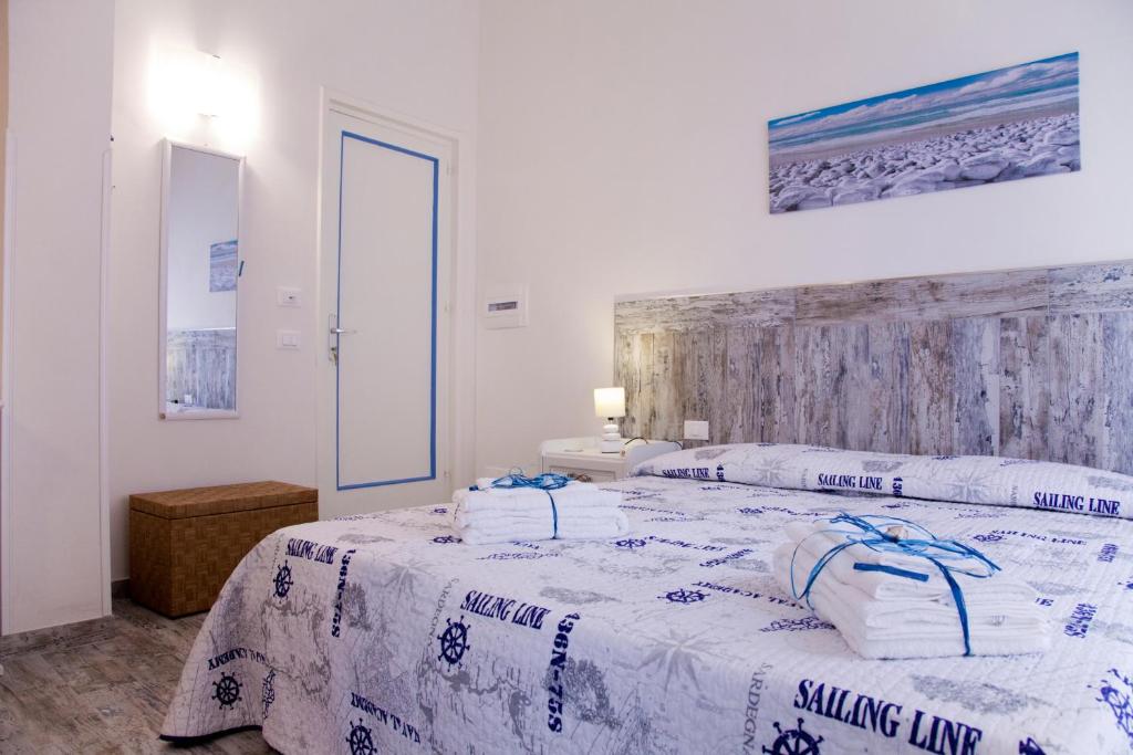 a bedroom with two beds with white sheets at Le Cale in Trapani