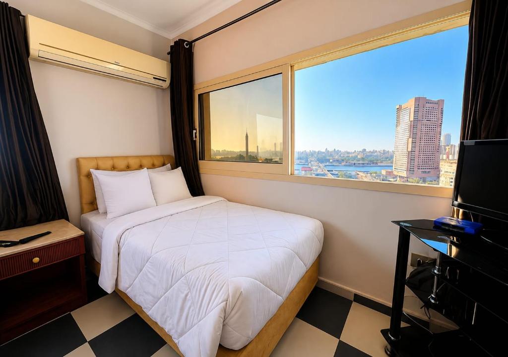 ein Schlafzimmer mit einem Bett und einem großen Fenster in der Unterkunft Isis Hostel 2 in Kairo