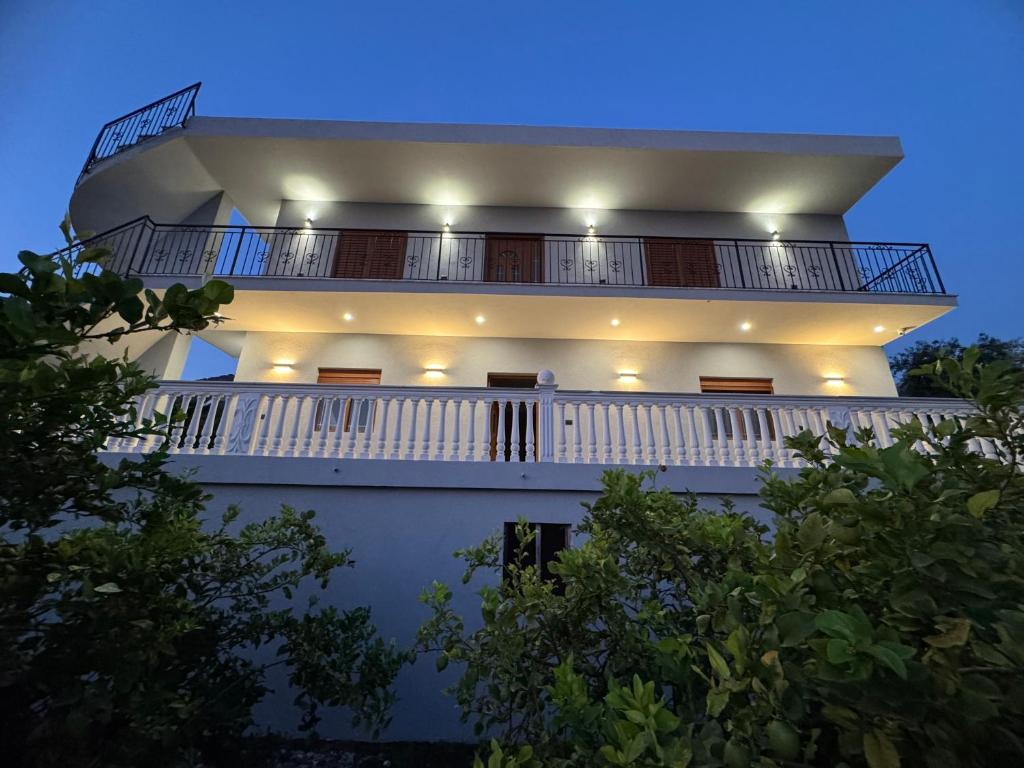 a white building with a balcony at night at Villa Denis Gjeta in Borsh