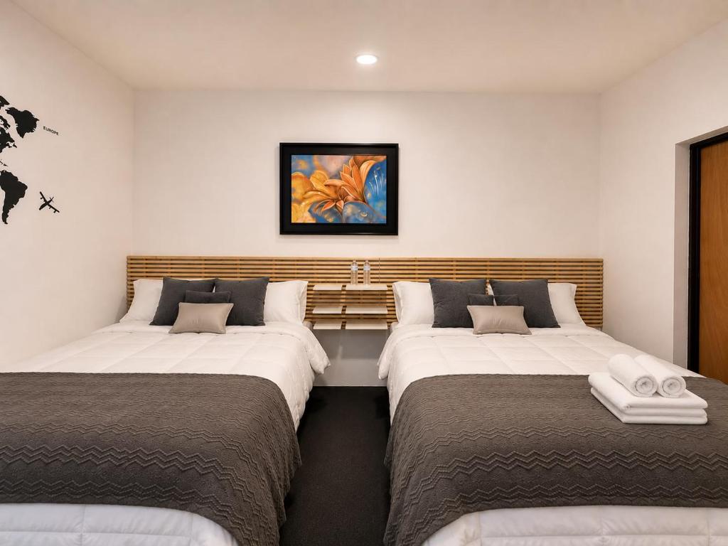 a room with three beds in a room at Hostal Boutique Zona Rosa - San Benito in San Salvador