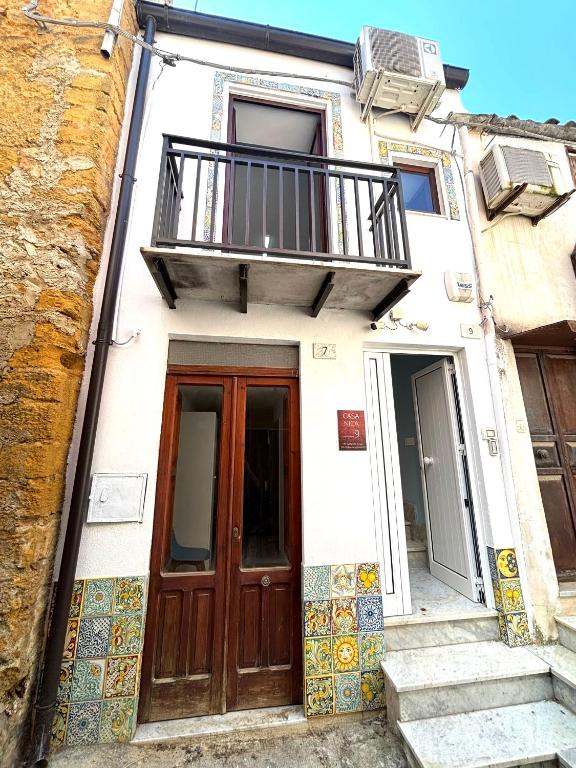 a building with a balcony and a door at Casa Nica in Naro