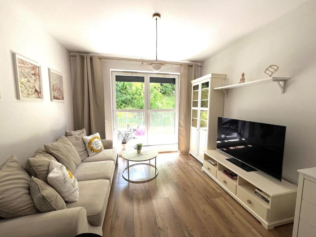a living room with a couch and a flat screen tv at Dolce Vita in Gdynia