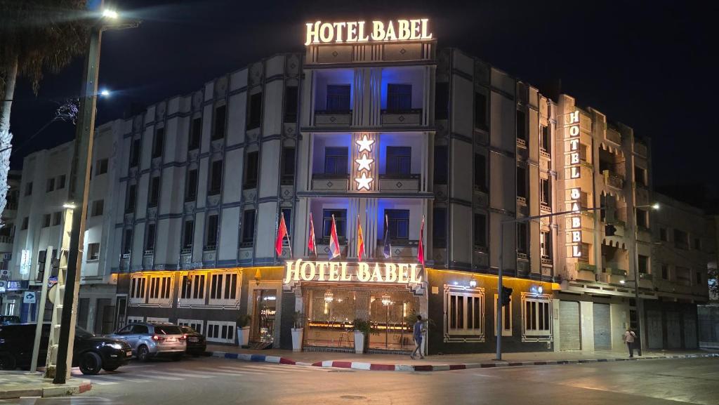 a hotel building with a sign on it at night at Hotel BouBabel in Nador