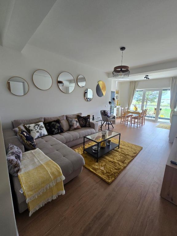 a living room with a couch and mirrors on the wall at Sunny Premium in Cristian