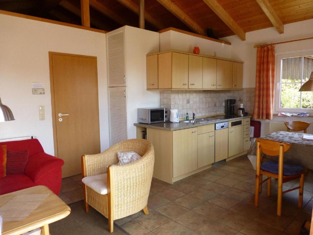 a kitchen with a red couch and a red chair at Ferienhaus Jabel 24 in Jabel