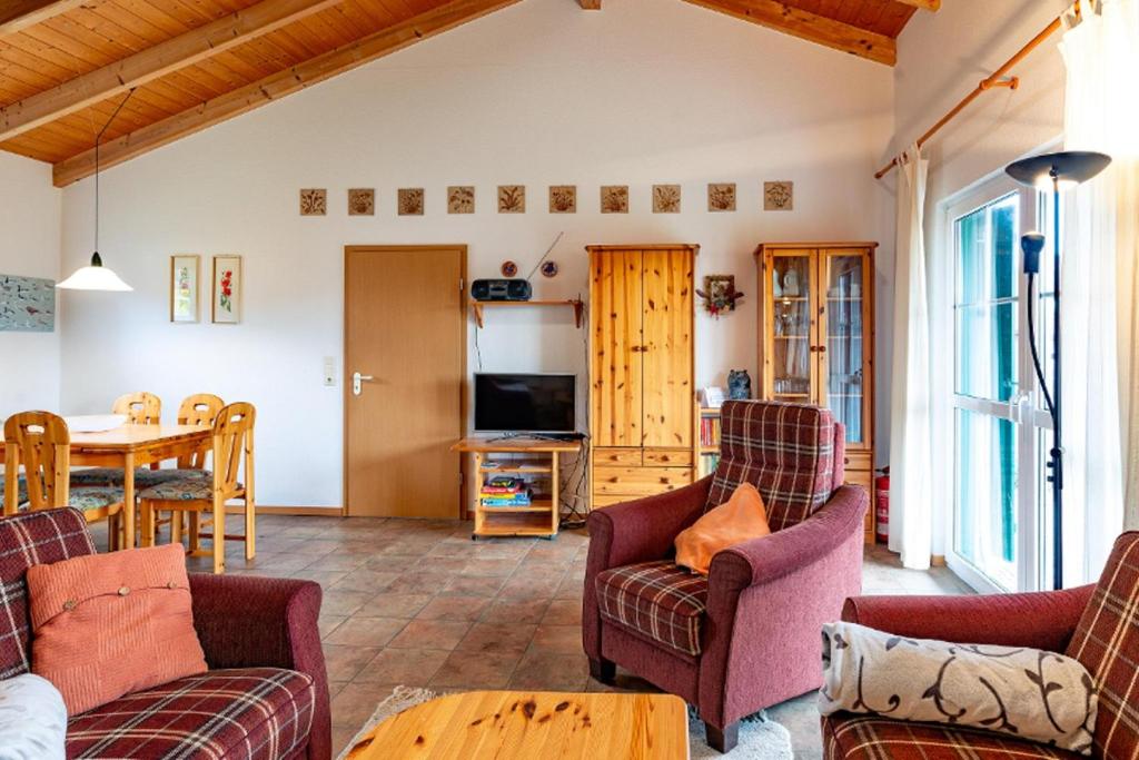 a living room with chairs and a table and a tv at Ferienhaus Jabel 25 in Jabel