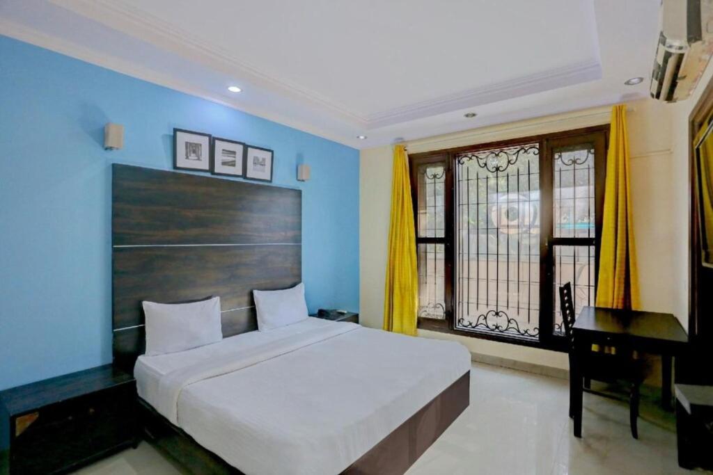 a bedroom with a large bed and a desk at Hotel Rastro Palace in New Delhi
