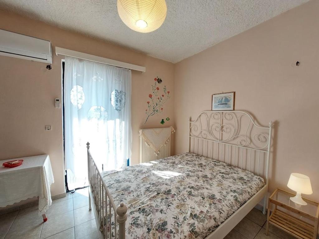 a bedroom with a bed and a large window at Dora's Sweet Home in Mytikas