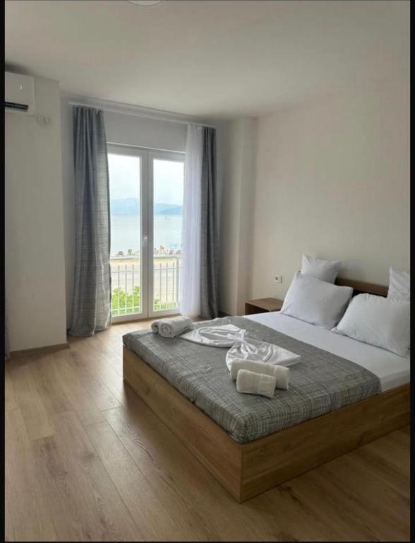a bedroom with a large bed and a large window at Villa Nesim in Struga