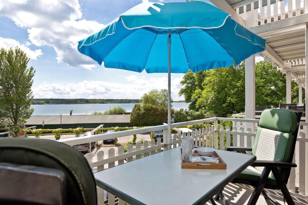 a table with a blue umbrella on a balcony at Kietzspeicher App 06 in Waren