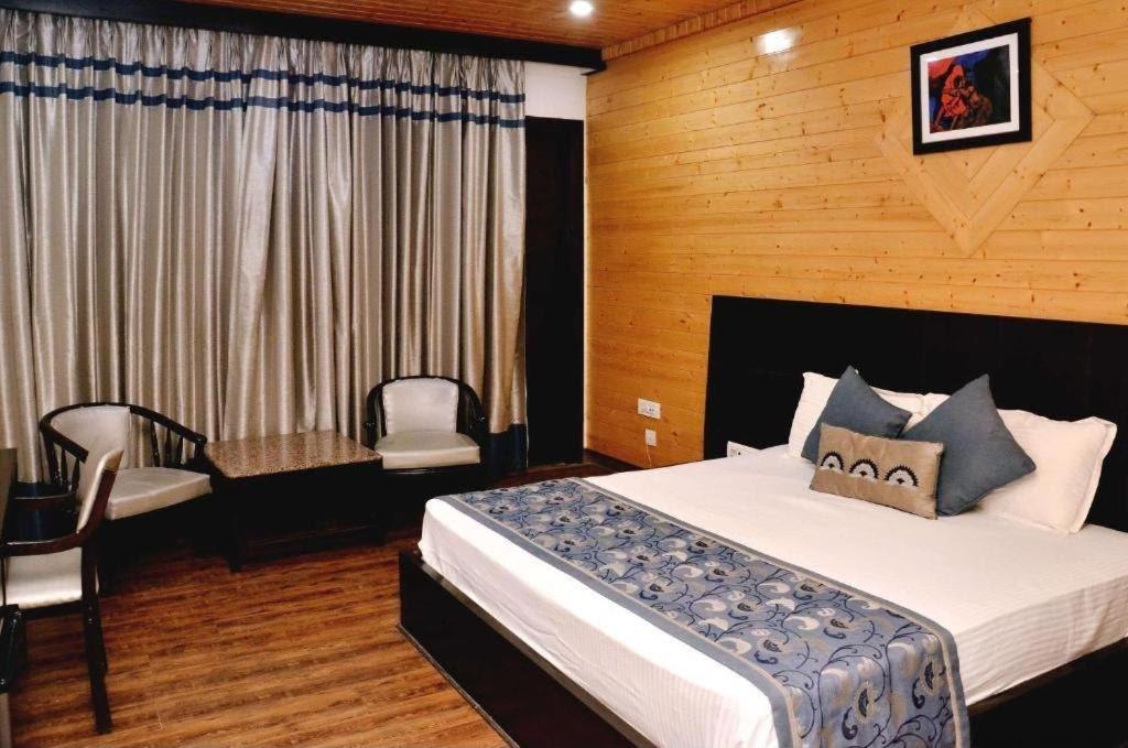 a bedroom with a bed and a table and a chair at Luxury Hotel Aura Residency in Rāiwāla