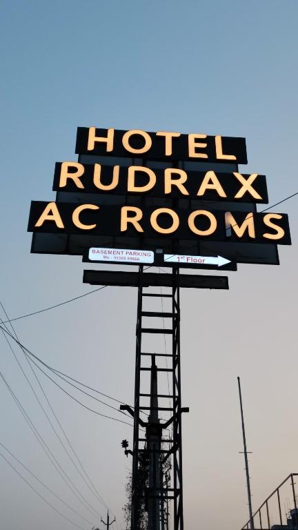 a sign for a hotel rutherford as rooms on a pole at Hotel Rudrax in Waghoria
