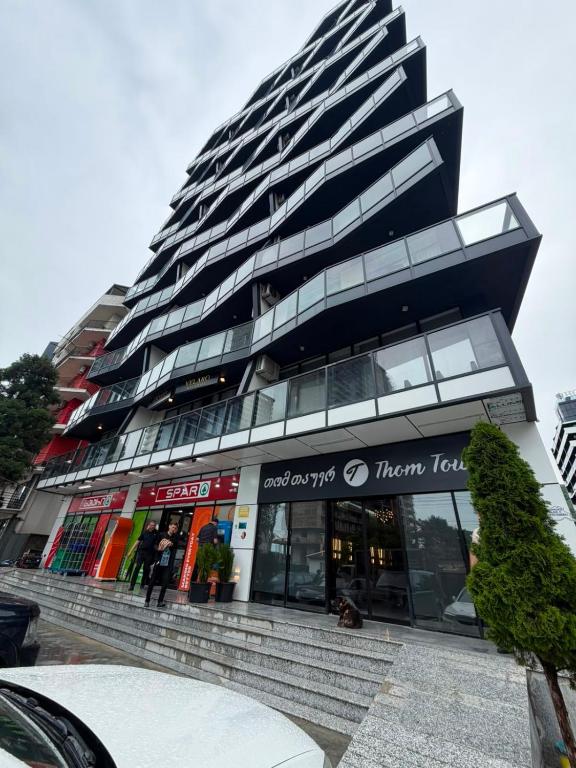 a large building with stairs in front of a building at Apartment in Gonio in Kvariati
