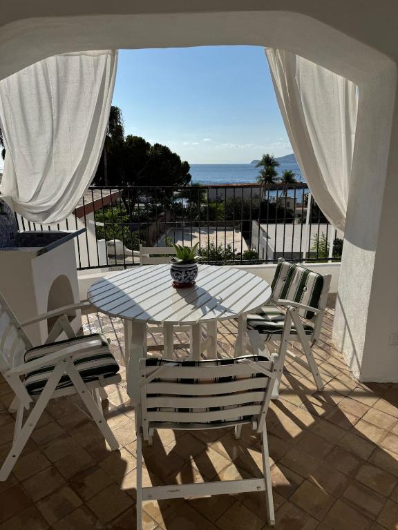 a table and chairs on a patio with the ocean at Il Portico sul mare in Santa Marina Salina