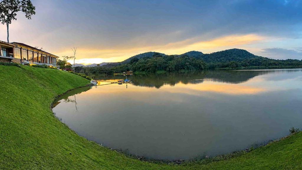 a view of a lake with a house and mountains at Denbi Eco Lodge in Greater Aman