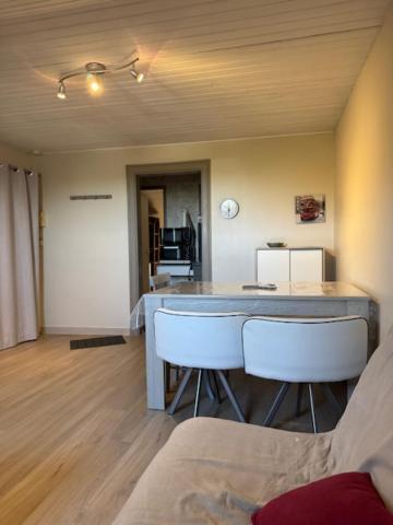 a kitchen with a counter and white stools in a room at T2 mansardé tout équipé in Limoges