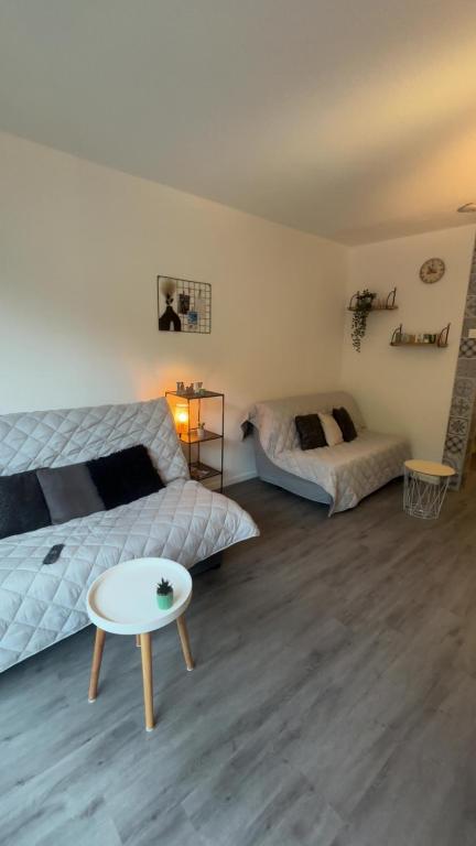a bedroom with two beds and a table at Studio le balcon pied des pistes in Villard-de-Lans